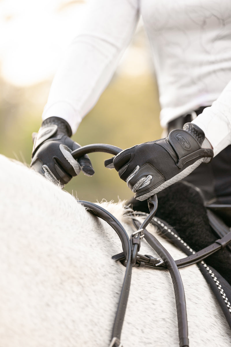 Front view of the Correct Connect Double Neck Strap showing rider using the handle  while on horse