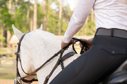 Rear view of the Correct Connect Double Neck Strap show casing the use of the handle strap with horse and rider